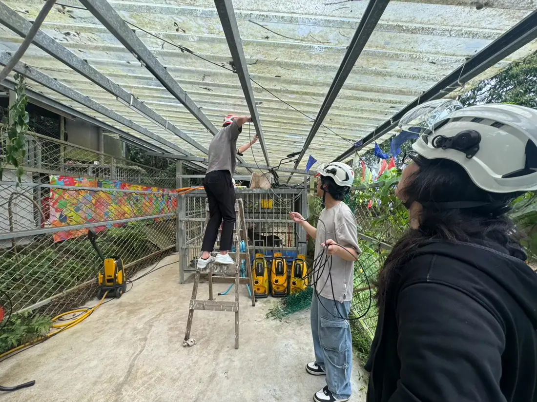 團隊成員戴著安全帽在收容所架設鏡頭線路